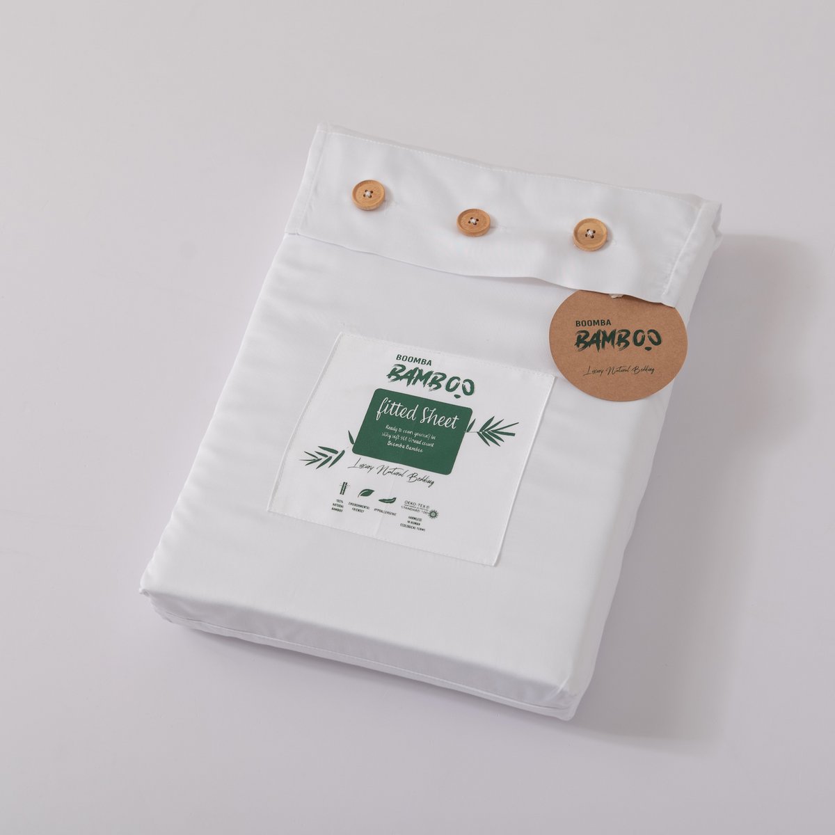 Coco White bamboo fitted sheet for mattress toppers folded and packaged with the Boomba Bamboo product label.