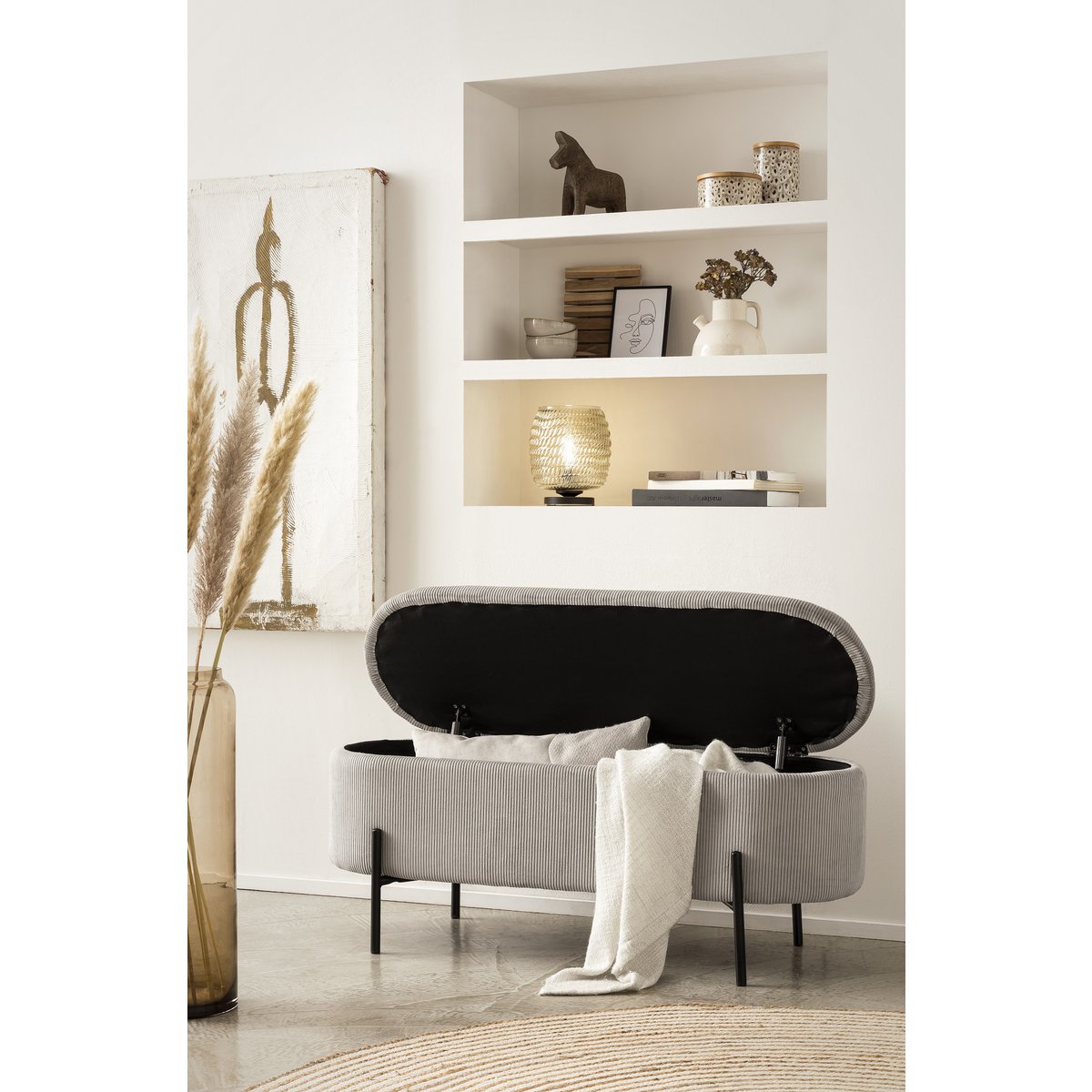 Light grey corduroy storage bed bench with the lid open and a throw draped over the edge